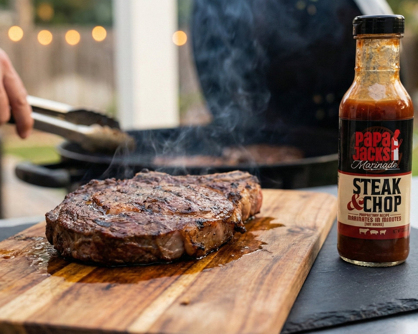 Steak on a cutting board with a bottle of steak sauce next to it, outdoors.